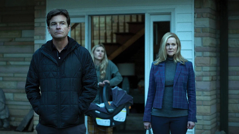 Marty (Jason Bateman) and Wendy Byrde (Laura Linney) stand quietly outside their home in Ozark