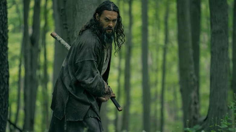 Baba Voss (Jason Momoa) readies his sword in the woods in See