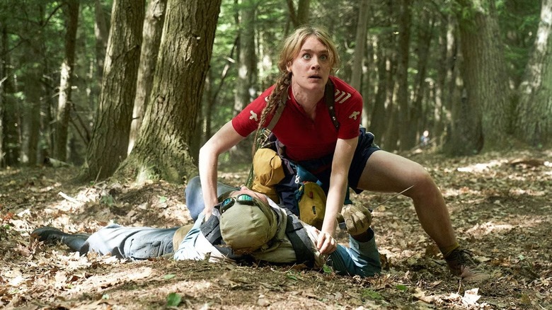 Kirsten Raymonde (Mackenzie Davis) crouches over a body in the woods in Station Eleven