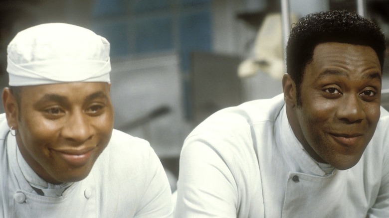 Roger Griffiths and Lenny Henry as Everton and Gareth smiling in the kitchen in Chef!