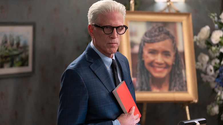 Charles Nieuwendyk (Ted Danson) holding a book on A Man on the Inside