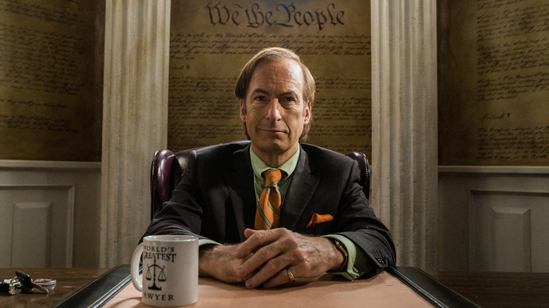 Bob Odenkirk as Saul Goodman, sitting at his desk on Better Call Saul
