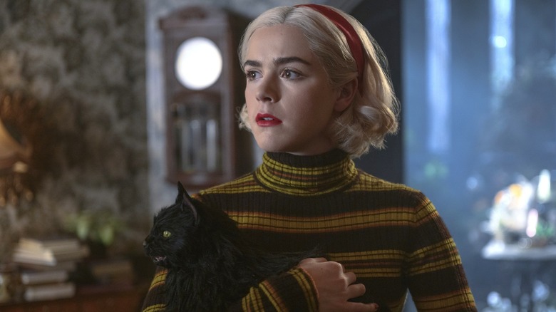 Kiernan Shipka's Sabrina Spellman holding Salem in Chilling Adventures of Sabrina