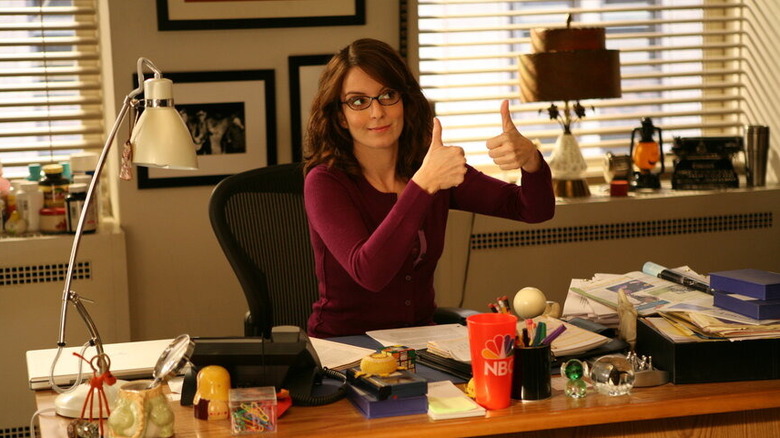 Tina Fey as Liz Lemon, raising two thumbs up on 30 Rock.