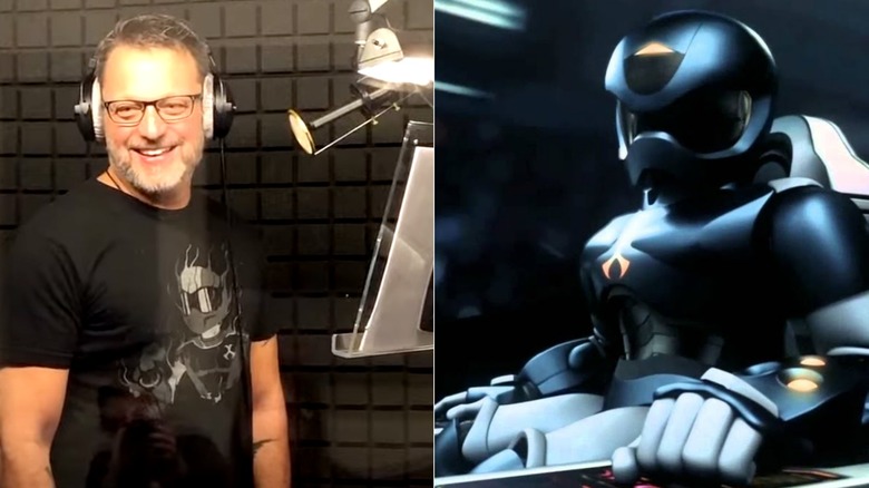 Steve Blum shouting into a microphone in the woods next to TOM 3.5 sitting in his command center chair during Toonami