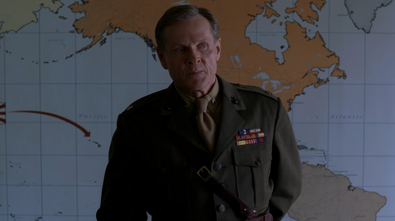 Lewis "Chesty" Puller (William Sadler) standing in front of map in The Pacific