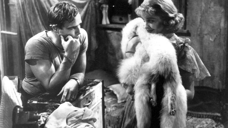 Stanley Kowalski (Marlon Brando) glares at Blanche DuBois (Vivien Leigh) as she holds a dog in A Streetcar Named Desire (1951)