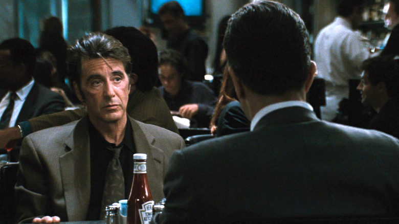 Vincent Hanna (Al Pacino) looks at Neil McCauley (Robert De Niro) in a diner seat in Heat (1995)