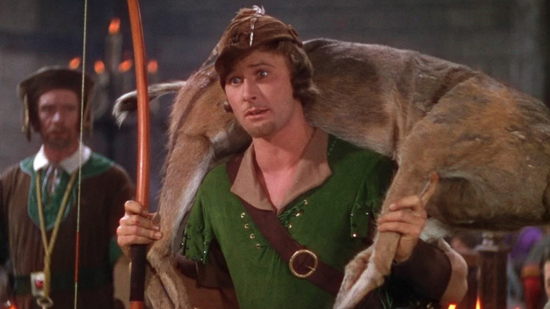 Robin Hood (Errol Flynn) holding a dead deer in the castle in The Adventures of Robin Hood