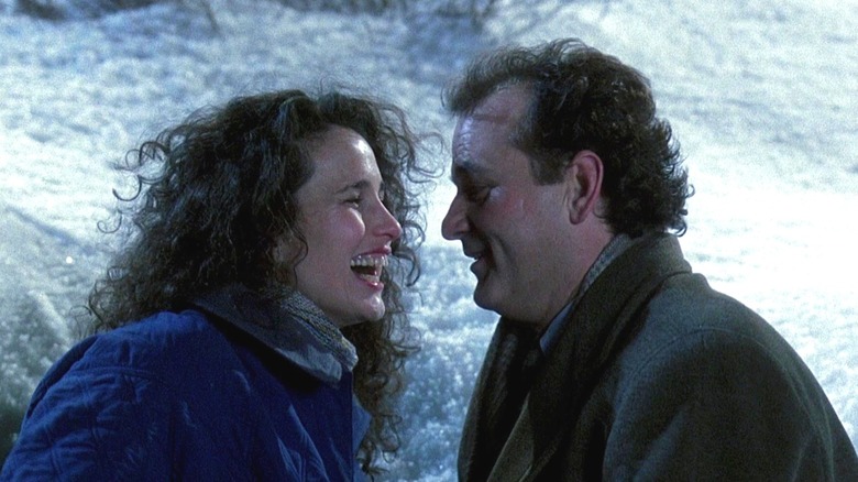 Andie Macdowell and Bill Murray as Rita and Phil lying in a snow pile in Groundhog Day