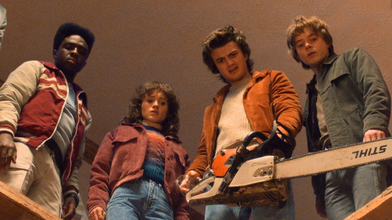 Lucas, Nancy, Steve, and Jonathan look town into a hole in Stranger Things.
