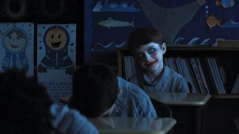 Cary Christopher as Alex, with his eyes wide and his face painted in Weapons.