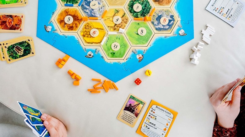 friends playing board game Catan