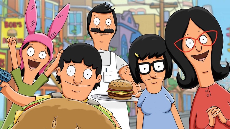 The Belcher family smiles at the camera, all standing together