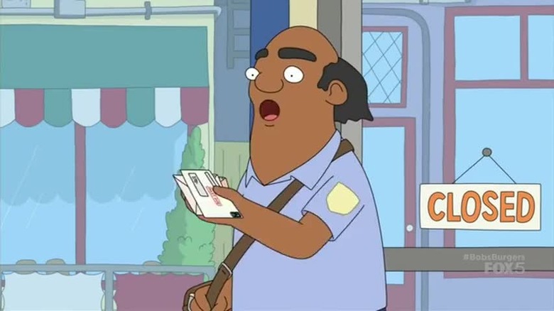 A mailman holds out a stack of mail