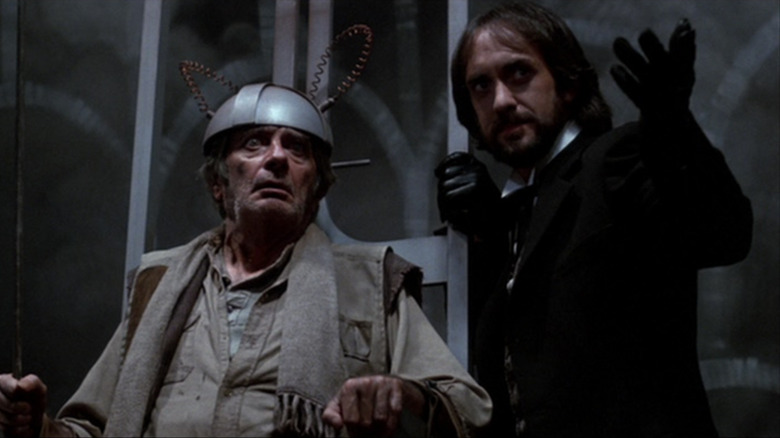 Jonathan Pryce as Mr. Dark next to a man in an electric chair in Something Wicked This Way Comes