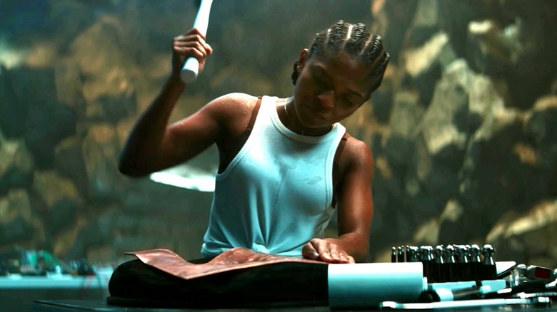 Riri Williams raises a hammer as she builds a new suit of armor in Ironheart (2025)