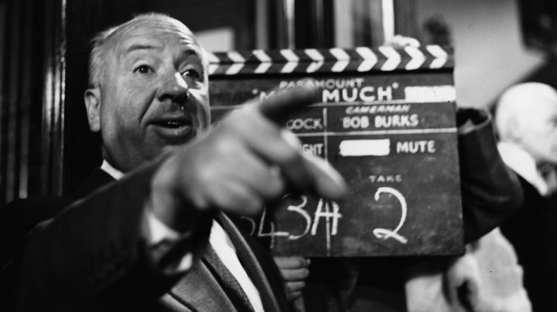 Alfred Hitchcock pointing in front of clapboard for The Man Who Knew Too Much