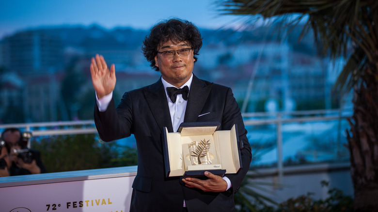 Bong Joon Ho waving while holding an award
