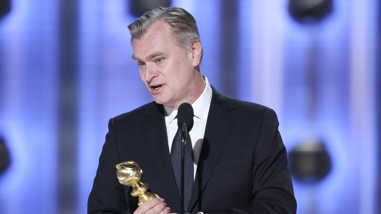 Christopher Nolan giving a speech while holding a Golden Globe