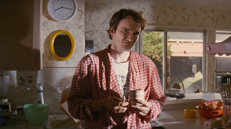 Jimmie (Quentin Tarantino) standing in front of a clock in Pulp Fiction