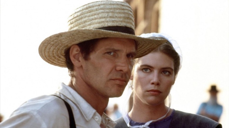 Harrison Ford as John, looking at trouble, and Kelly McGillis as Rachel, looking at John, in Witness