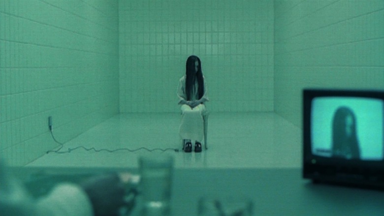 Samara (Daveigh Chase) sits on a chair in the middle of a sterile white room in The Ring