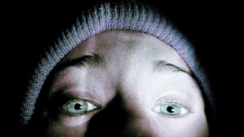 Close-up of the top of Heather Donahue as Heather's face lit up by flashlight in The Blair Witch Project