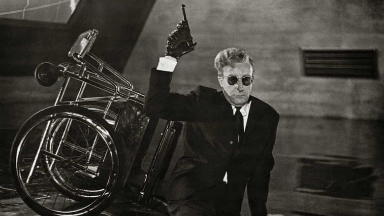 Dr Strangelove holds pistol