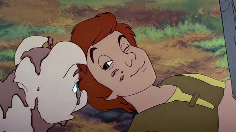 Taran (Grant Bardsley) plays with a pig in The Black Cauldron