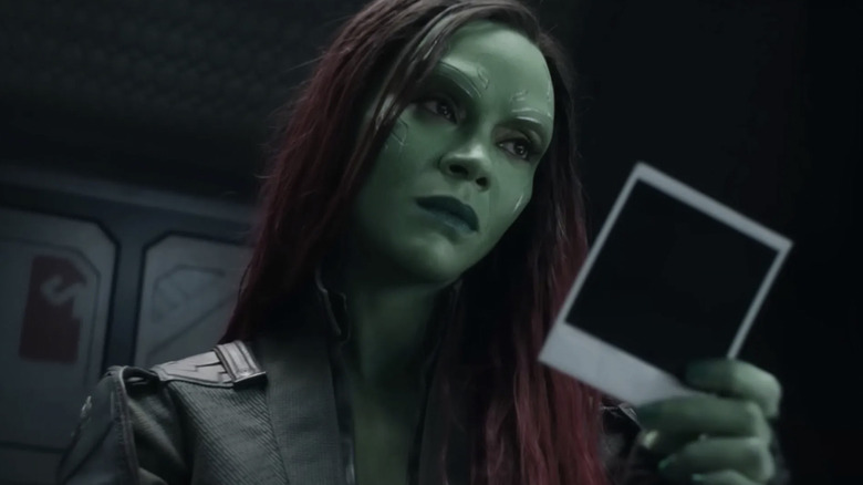 Zoe Saldana as Gamora holding a polaroid in Guardians of the Galaxy Vol. 3