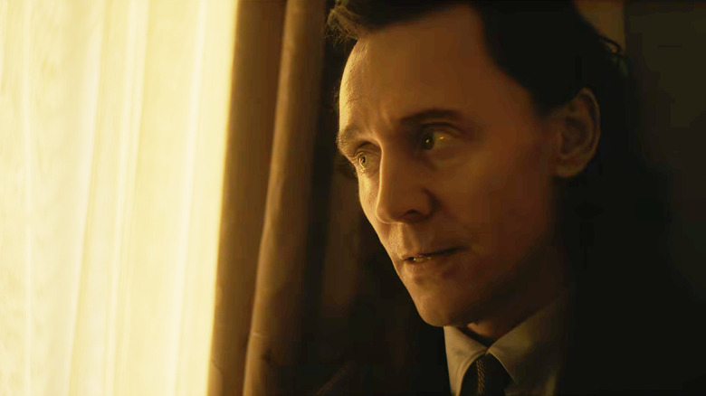 Tom Hiddleston as Loki looking worried next to a yellow curtain in Avengers: Doomsday
