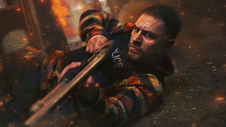 Tom Hardy as Patrick Walker, lying on the floor with a shotgun in Havoc