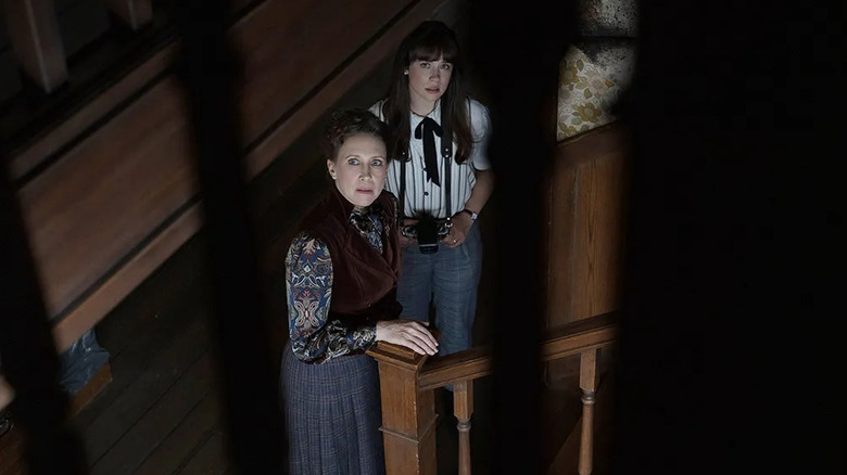 Vera Farmiga and Mia Tomlinson as Lorraine and Judy Warren, looking up through a staircase in The Conjuring: Last Rites