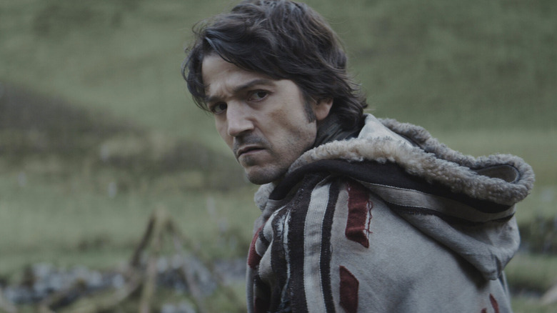 Diego Luna as Cassian Andor scowling and wearing a fur hood in Andor