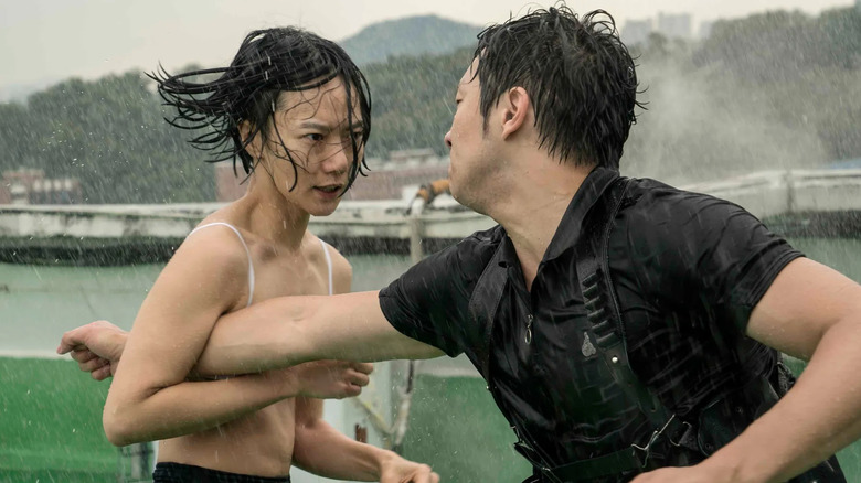 Bae Doona as Sun holding a man's arm in her armpit in the rain in Sense8