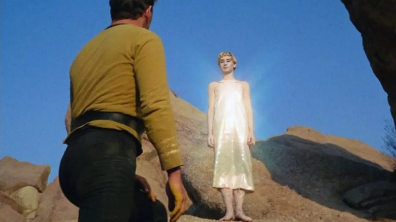 Kirk (William Shatner) looks at a Metron (Carole Shelyne) shimmering above him in Star Trek: The Original Series