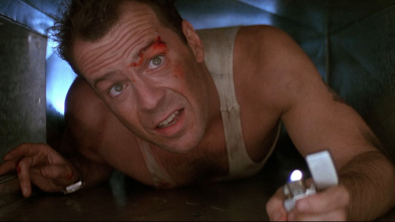 Bruce Willis as John McClane in Die Hard, crawling through an air duct with just a lighter to light his way.