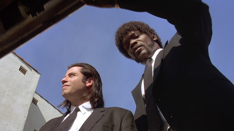John Travolta as Vincent Vega and Samuel L. Jackson as Jules Winnfield in Pulp Fiction, from the perspective of inside an open car trunk as Jules looks in and Vincent looks on above.