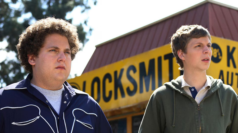 Jonah Hill as Seth and Michael Cera as Evan in Superbad, standing in front of a locksmith shop and looking off at something out of frame.