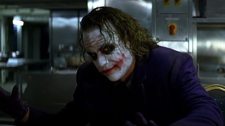 Heath Ledger as The Joker in The Dark Knight, looking menacingly off at someone out of frame.