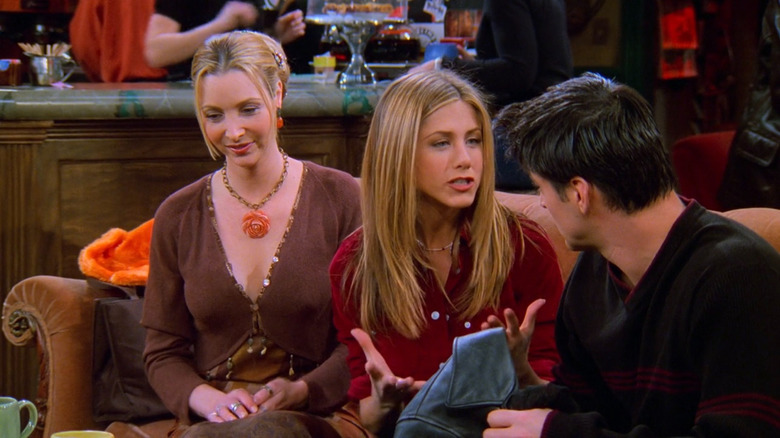 Rachel (Jennifer Aniston), Phoebe (Lisa Kudrow), and Joey (Matt LeBlanc) sitting on a couch on Friends