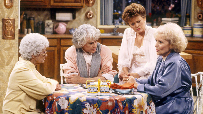 Betty White, Bea Arthur, Estelle Getty, and Rue McClanahan sitting at the kitchen table in The Golden Girls