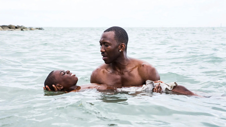 Mahershala Ali as Juan, holding Alex Hibbert as Little Chiron in Moonlight.