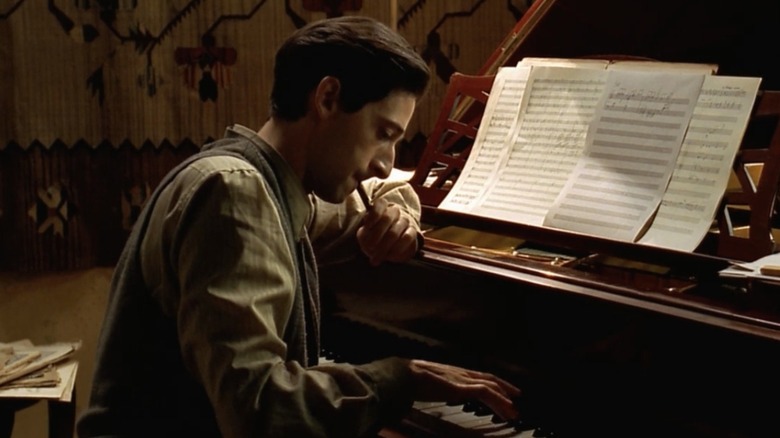 Adrien Brody as Władysław Szpilman, sitting at the piano in The Pianist.