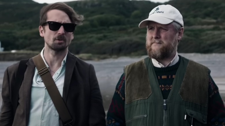 Tom Basden's Herb McGwyer and Tim Key's Charles Heath standing on a beach in The Ballad of Wallis Island