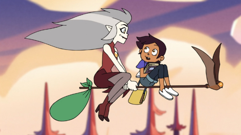 Eda and Luz ride on a broom together in The Owl House