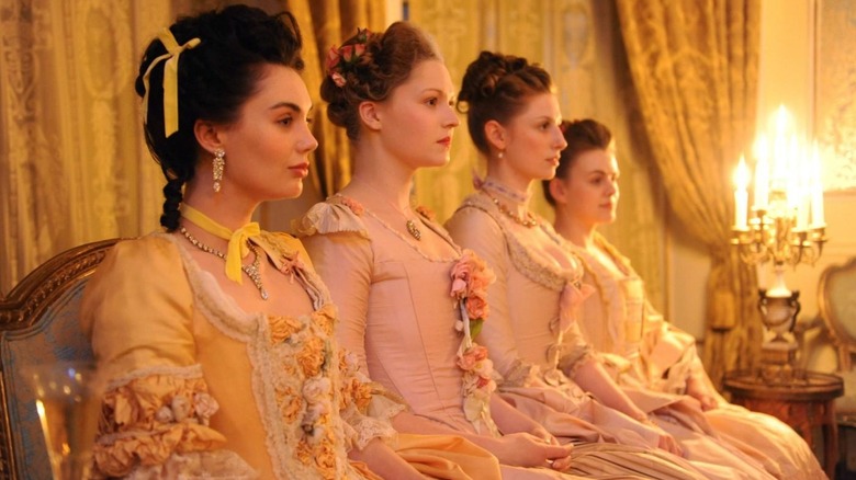 Four women sitting together in Victorian attire in Harlots