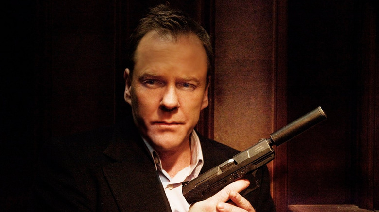 Kiefer Sutherland as the confessor holding a silenced pistol in the confession