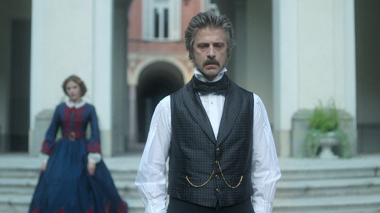 Kim Rossi Stuart as Prince of Salina standing on stairs in a courtyard in The Leopard